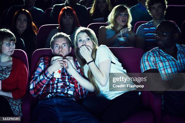 couple enjoying a movie at the cinema - aterrorizado imagens e fotografias de stock