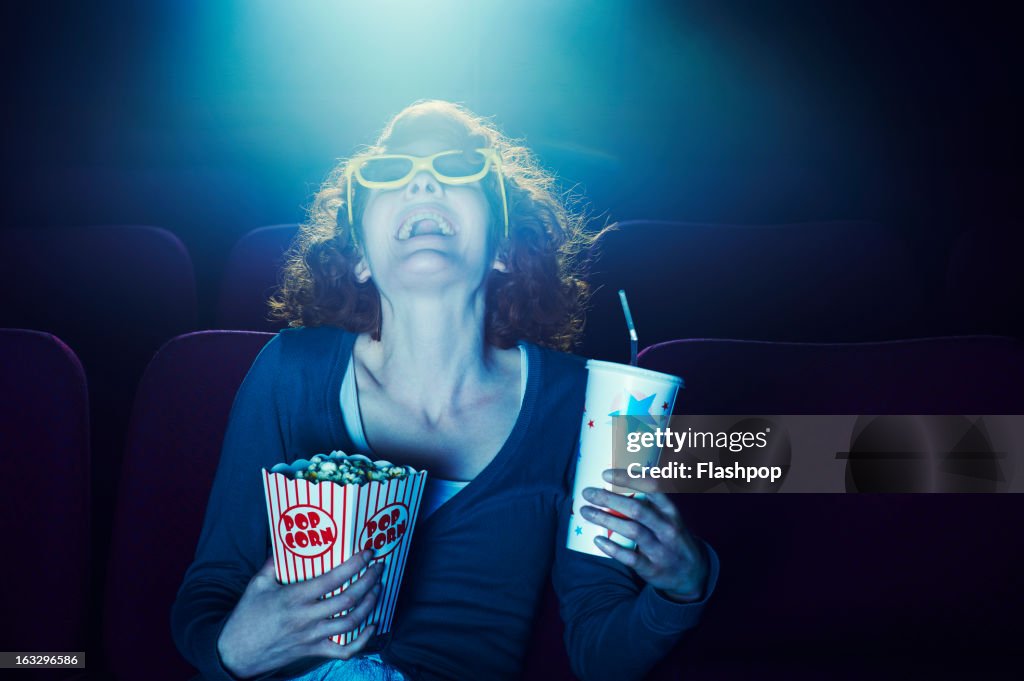 Woman enjoying movie at cinema