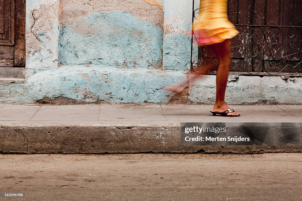 Passing feet of girl in yellow skirt