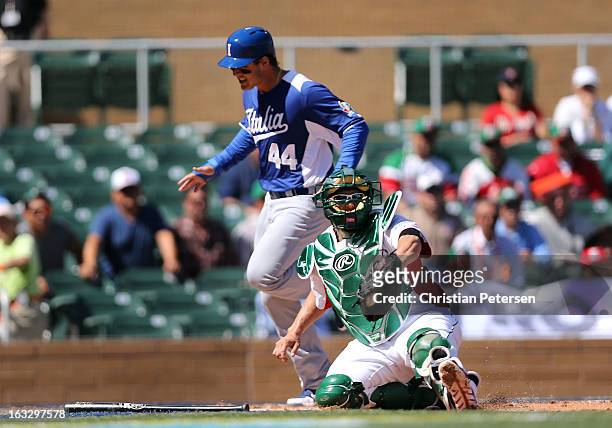 Catcher Humberto Cota of Mexico catches the ball late as Anthony Rizzo of Italy safely scores a first inning run during the World Baseball Classic...