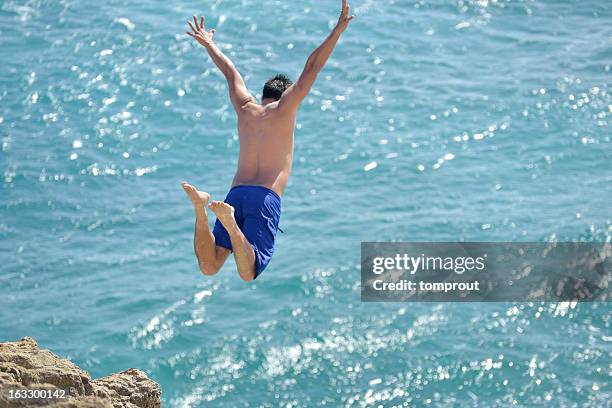 cliff diving in kauai, hawaii, usa - klippenspringen stock-fotos und bilder