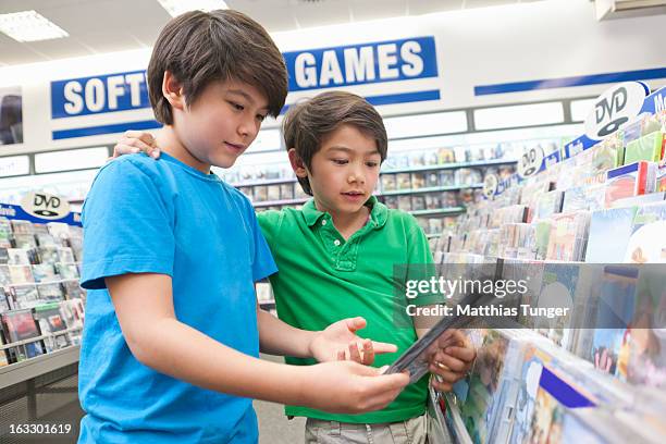 two boys looking for dvds to buy - dvd photos et images de collection