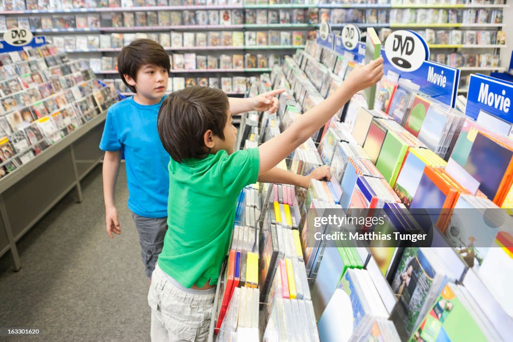 Two young boys searching for DVDs to buy