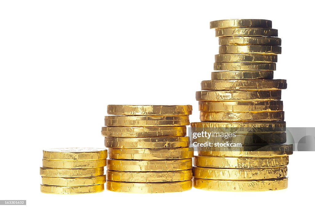 Chocolate money coins stacked on white