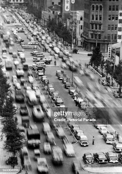 Traffic problem is illustrated in this photo, cars parked tail to bumper along every available foot of space in Tokyo Japan, 1955.