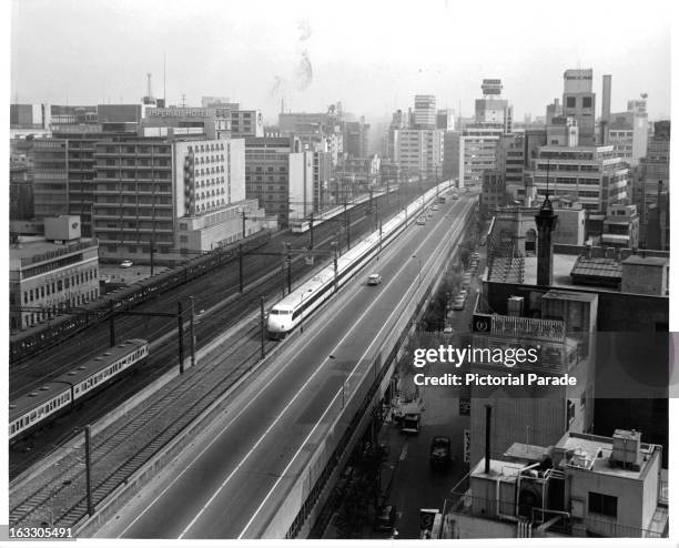 New high speed express train called 'Hikari' is traveling down the railroad tracks parallel to the highway in Tokyo, Japan, 1955.