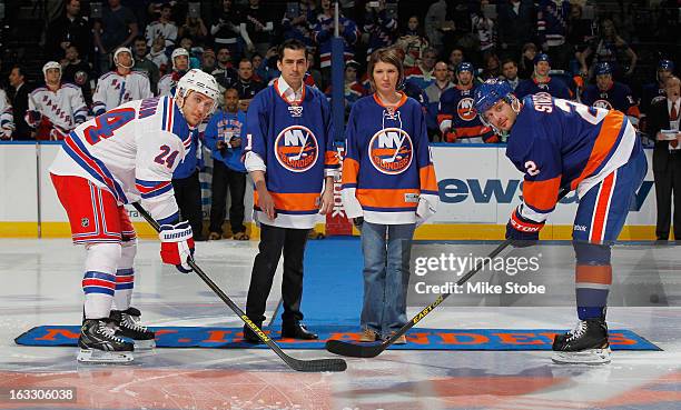 Ryan Callahan of the New York Rangers and Mark Streit of the New York Islanders come out for the ceremonial puck drop with Katie Beers and Cameron...