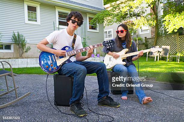 garage band - outdoor guy sitting on a rock stockfoto's en -beelden