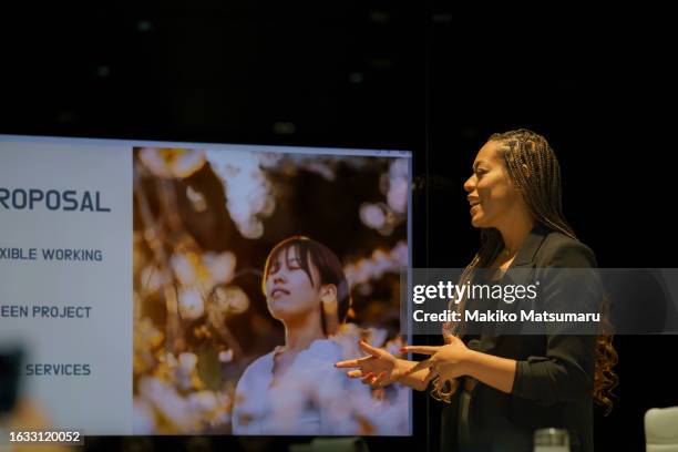 african american woman giving a presentation with slides in a conference room. - verkaufsargument stock-fotos und bilder