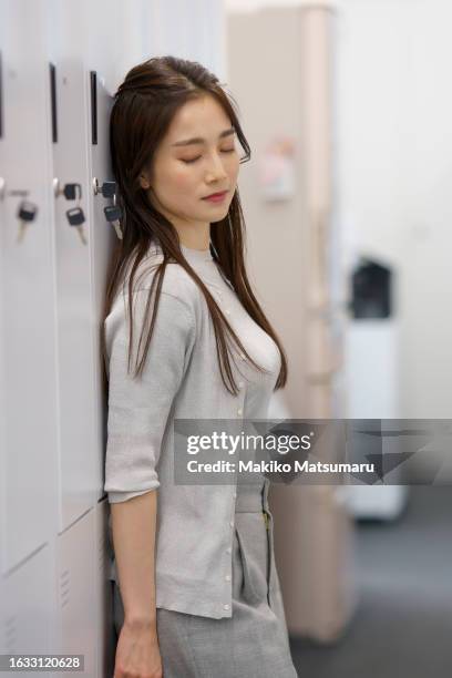 pensive woman standing in locker room. - 舞台裏　日本 ストックフォトと画像