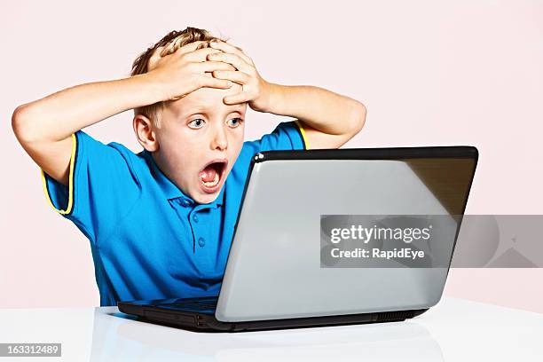 blond 9-year-old boy is shocked by something on his laptop - porr bildbanksfoton och bilder