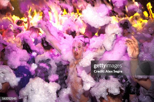 Young clubbers having fun at foam party in nightclub in San Antonio, Ibiza