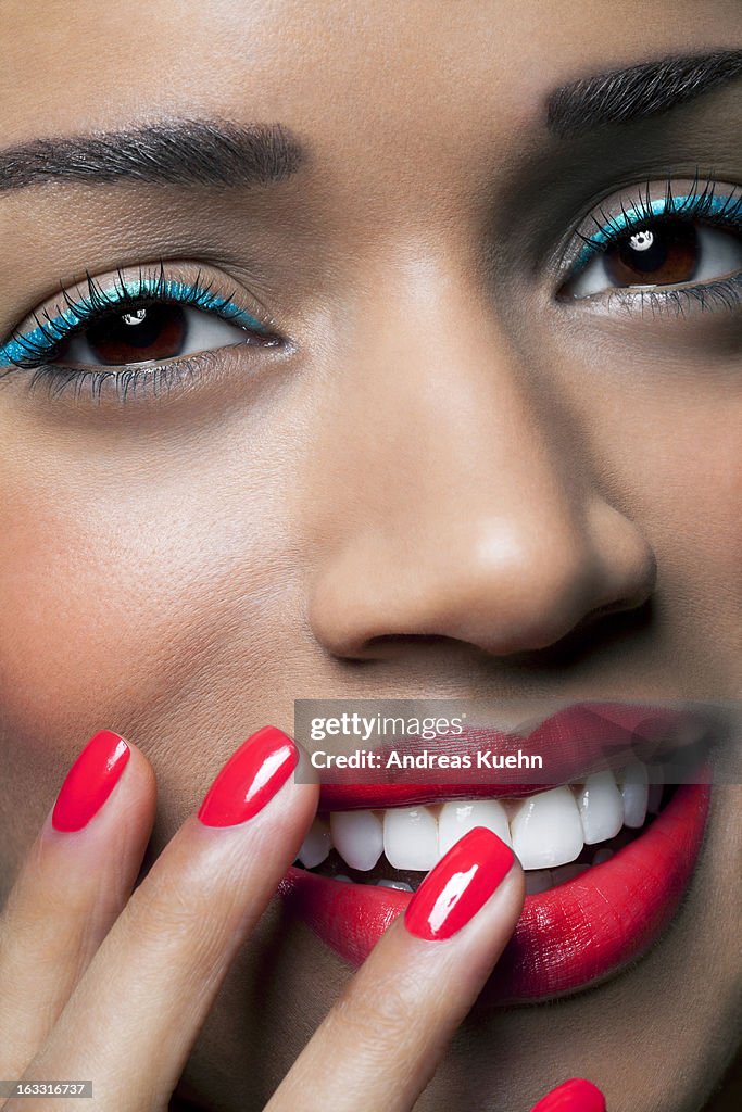 Young woman with colorful make up and nails.