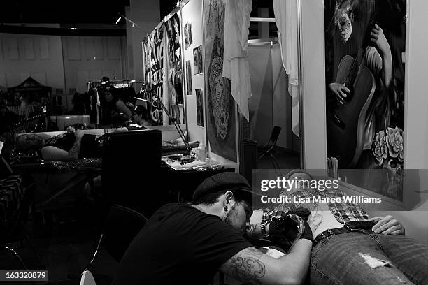 Tattoo artist Jimi May works on a woman's stomach during The Australian Tattoo & Body Art Expo at the Royal Hall of Industries, Moore Park on March...