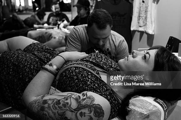 Woman is tattooed during The Australian Tattoo & Body Art Expo at the Royal Hall of Industries, Moore Park on March 8, 2013 in Sydney, Australia. The...
