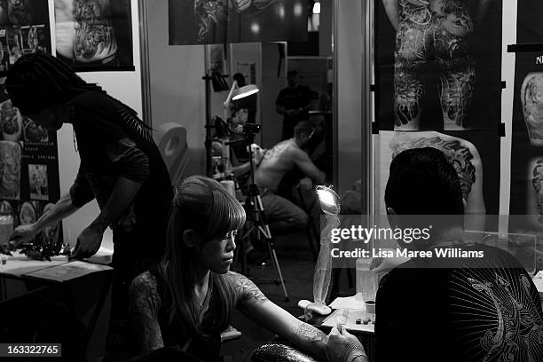 Tattoo artists from 'Night Action Tattoo' in Taiwan work on clients during The Australian Tattoo & Body Art Expo at the Royal Hall of Industries,...