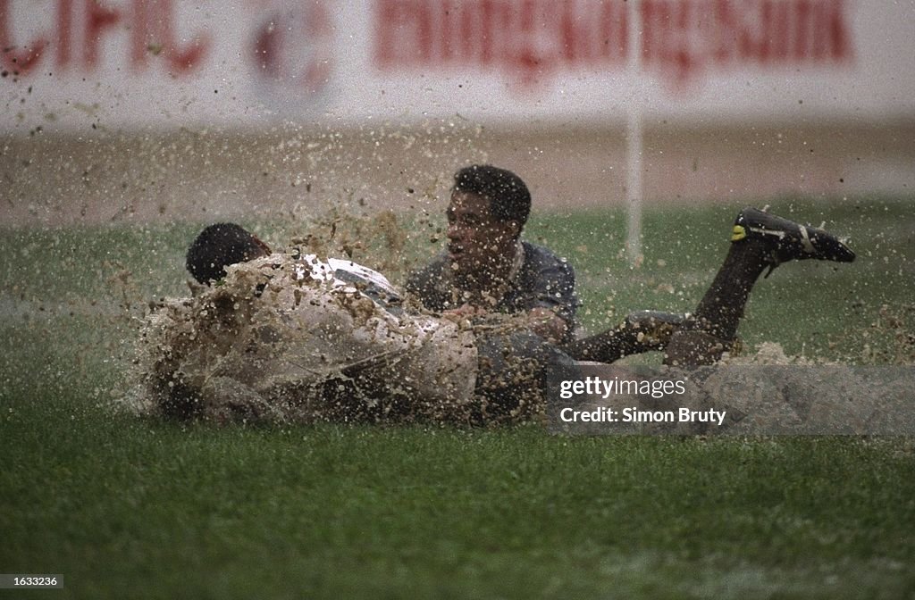 Pat Lam of New Zealand in brought down into the mud and rain water