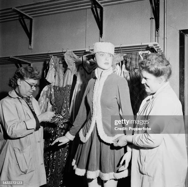 'Television Tilly', a wax model 'stand-in' for artists during lighting tests, is dressed by wardrobe mistress Mrs Robb and her assistant backstage at...