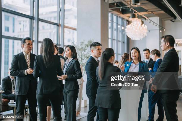gruppe von multirassischen asiatischen geschäftsteilnehmern unterhält sich nach erfolgreicher konferenzveranstaltung - großer speisesaal stock-fotos und bilder