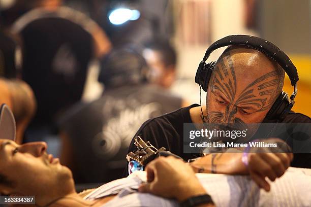 Tattoo artist Turumakina tattoos a young man's arm during The Australian Tattoo & Body Art Expo at the Royal Hall of Industries, Moore Park on March...