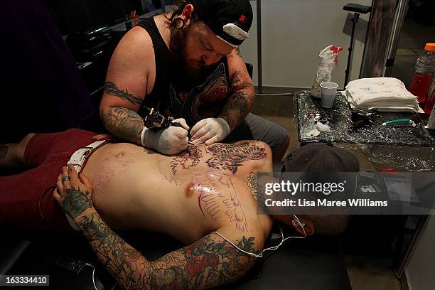 Man is tattooed during The Australian Tattoo & Body Art Expo at the Royal Hall of Industries, Moore Park on March 8, 2013 in Sydney, Australia. The...