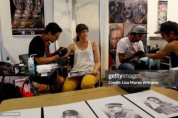 Tattoo artist Peter Nieves tattoos a young woman's arm during The Australian Tattoo & Body Art Expo at the Royal Hall of Industries, Moore Park on...