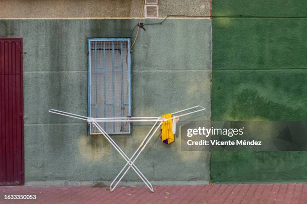 folding clothesline on the sidewalk - ropa tendida fotografías e imágenes de stock