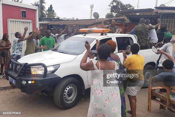 Residents applaud members of the security forces in the Plein Ciel district Libreville on August 30, 2023 after a group of Gabonese military officers...