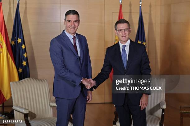 People's Party President Alberto Nunez Feijoo shakes hands with Spanish acting Prime Minister and Socialist Party Secretary General Pedro Sanchez...