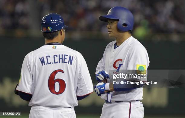 Cheng-Min Peng of Chinese Taipei talks with coach Wei-Cheng Chen after hits a RBI single in the fifth inning during the World Baseball Classic Second...