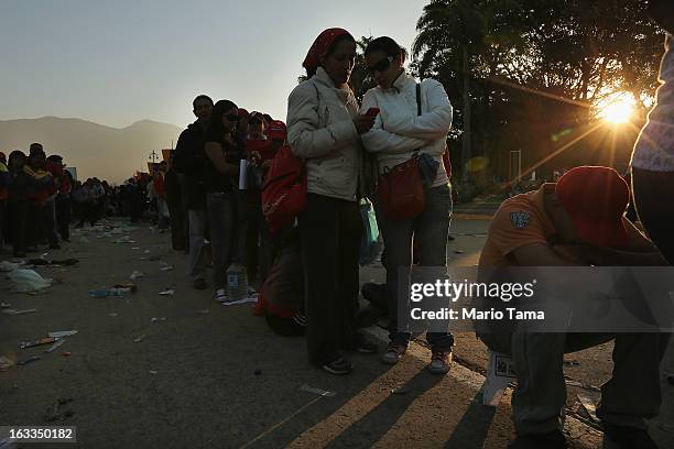 People wait in line before the start of the funeral for Venezuelan President Hugo Chavez outside the Military Academy on March 8, 2013 in Caracas,...