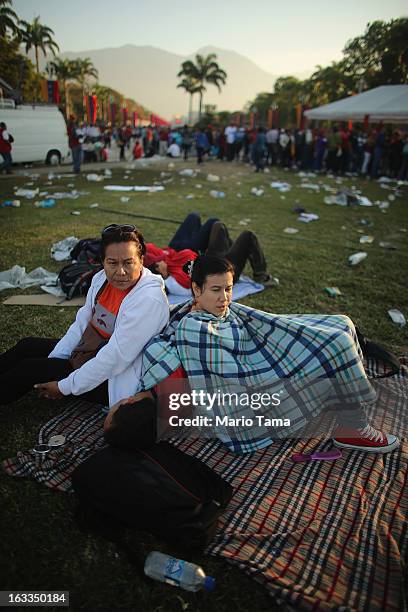 People wait before the start of the funeral for Venezuelan President Hugo Chavez outside the Military Academy on March 8, 2013 in Caracas, Venezuela....