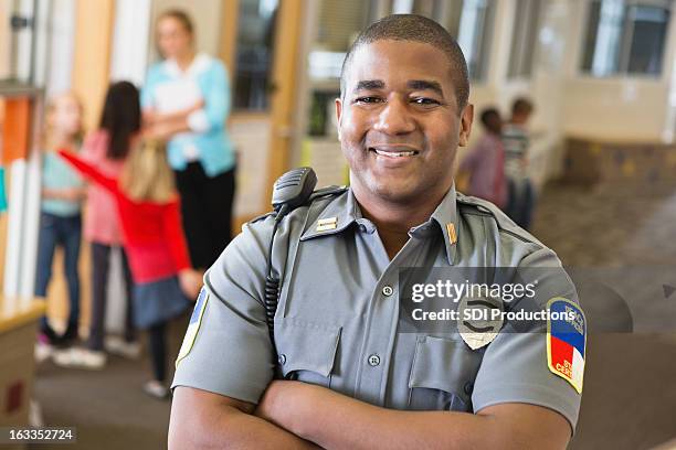 smiling friendly police officer providing security on school campus - campus safety stock pictures, royalty-free photos & images