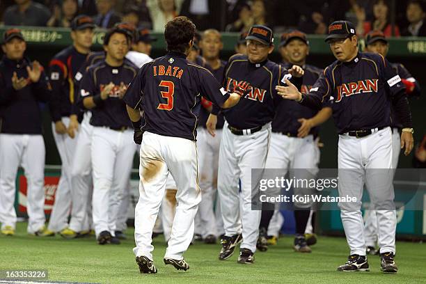 Infielder Hirokazu Ibata of Japan and Japan Head Coach Koji Yamamoto celebrate after hitting a RBI single in the top half of the ninth inning during...