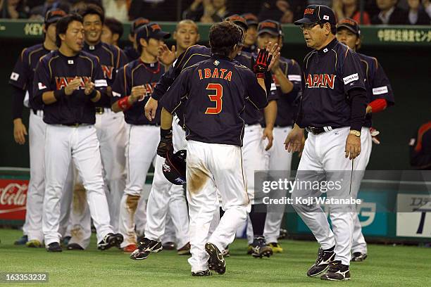 Infielder Hirokazu Ibata of Japan and Japan Head Coach Koji Yamamoto celebrate after hitting a RBI single in the top half of the ninth inning during...