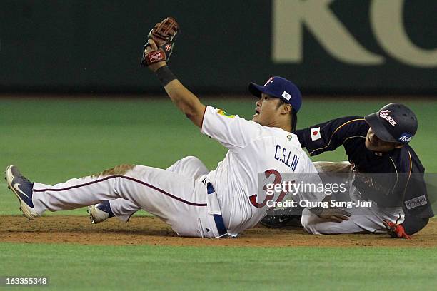 Takashi Toritani of Japan slides safely into second base as Chih-Sheng Lin of Chinese Taipei tries to tag him in the ninth inning during the World...