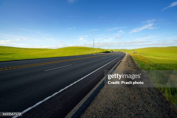 car on the road going in the american countryside with cow farm, meadow, stream and mountain in background. - via láctea fotografías e imágenes de stock