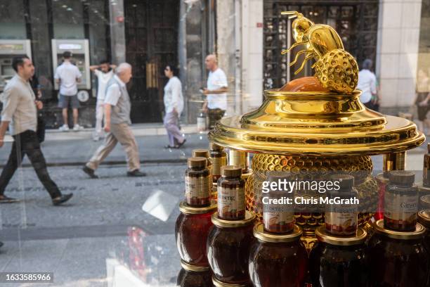 People walk on the street past a shop specializing in honey products on August 23, 2023 in Istanbul, Turkey. Turkey is the world's second largest...