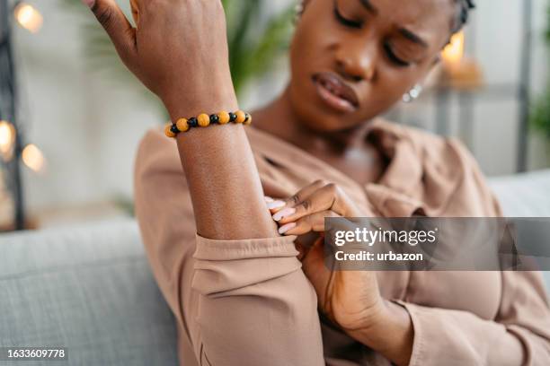 young woman scratching her skin at home - mosquito bite stock pictures, royalty-free photos & images