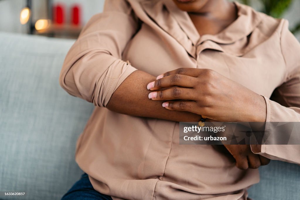 Young Woman Scratching Her Skin At Home