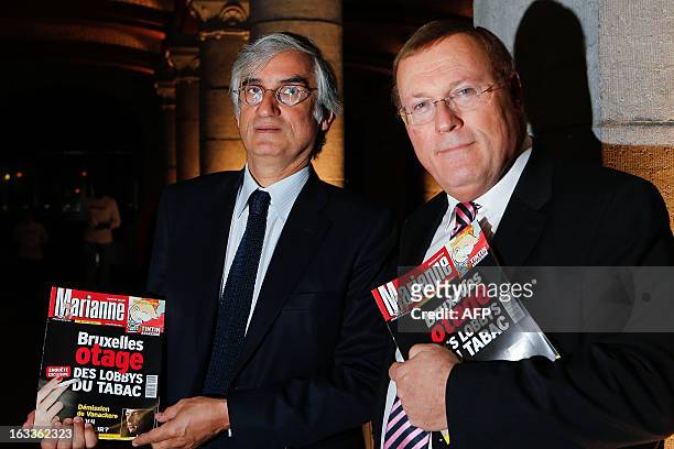 French weekly news magazine "Marianne" director, Maurice Szafran and Pascal Vrebos, director of "Marianne" Belgian edition pose with copies of the...