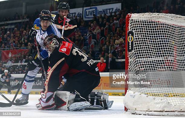 Dimitri Paetzold , goaltender of Hannover saves the shot of Benedikt Brueckner of Straubing battle for the puck during the DEL match between Hannover...
