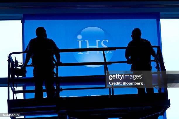 Hotel workers remove decorative banners at the conclusion of the 2013 IHS CERAWeek conference in Houston, Texas, U.S., on Friday, March 8, 2013. IHS...