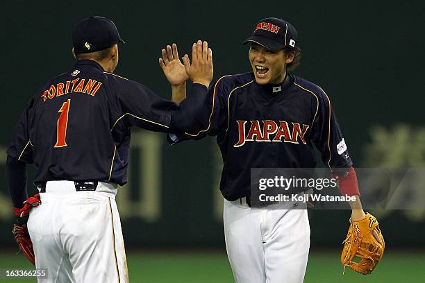 Infielder Hayato Sakamoto and Takashi Toritani of Japan celebrate after winning the World Baseball Classic Second Round Pool 1 game between Japan and...