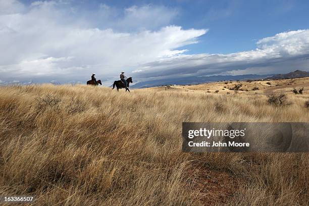 Border Patrol ranch liaison John "Cody" Jackson rides with cattle rancher Dan Bell on Bell's ZZ Cattle Ranch at the U.S.-Mexico border on March 8,...