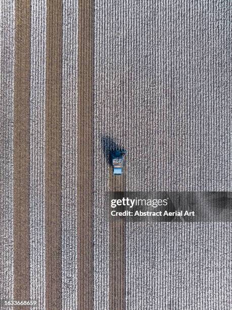 drone photograph looking down on an agricultural machine harvesting a cotton field, queensland, australia - cotton plant vertical image stock pictures, royalty-free photos & images