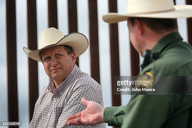 Border Patrol ranch liaison John "Cody" Jackson speaks with cattle rancher Dan Bell on Bell's ZZ Cattle Ranch at the U.S.-Mexico border fence on...