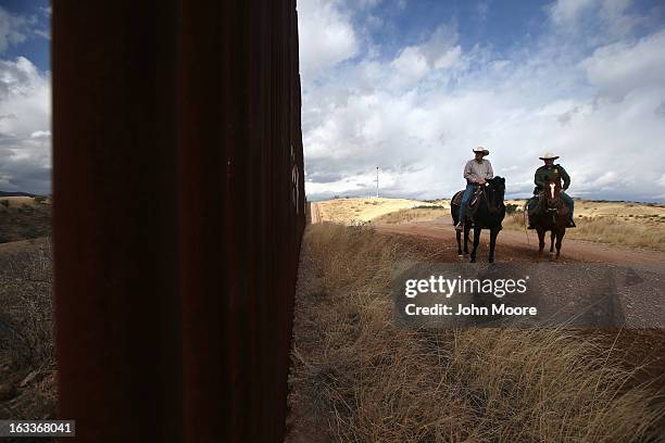 Border Patrol ranch liaison John "Cody" Jackson rides with cattle rancher Dan Bell on Bell's ZZ Cattle Ranch at the U.S.-Mexico border on March 8,...