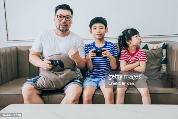 father and son playing games on home appliances - 活動 stock pictures, royalty-free photos & images