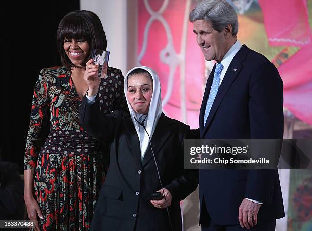 Afghanistan Counter Narcotics Police First Sergeant Malalai Bahaduri holds up her International Women of Courage award while posing for photographs...